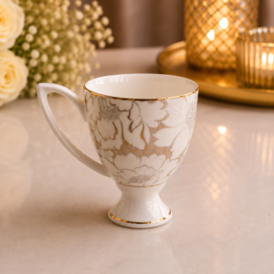 White floral ceramic mug set with elegant beige flower pattern, gold rim, and pedestal base.