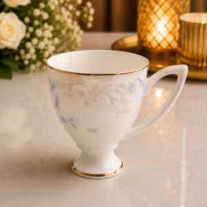 Elegant white floral ceramic mug set with gold rim and premium finish on a luxury marble surface.